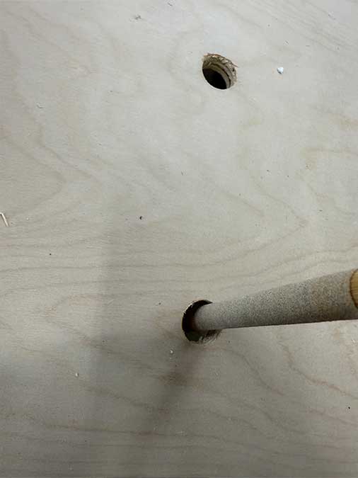 Sanding dowel spinning inside a peg-board style hole on a shelf wall