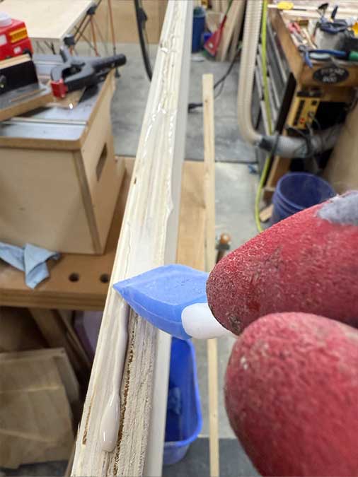 Spreading wood glue evenly with a flexible spatula
